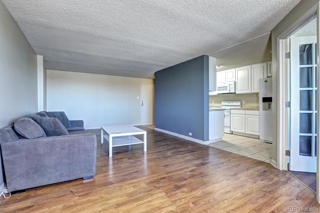 living room with light hardwood / wood-style flooring and a textured ceiling