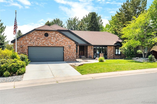 3253 S King Way, Denver, CO 80236 - view of front of house with an attached garage, concrete driveway, a front yard, and brick siding