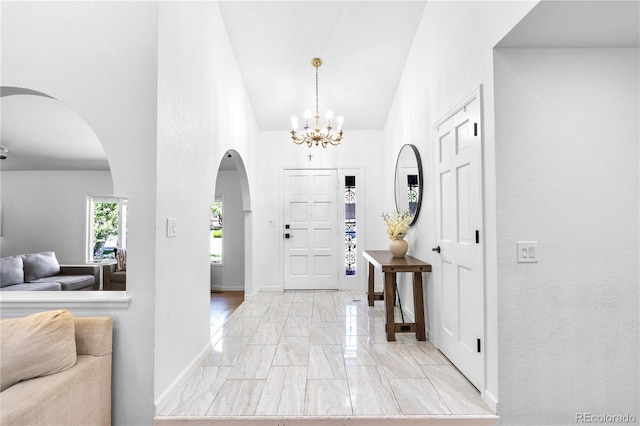 3253 S King Way, Denver, CO 80236 - foyer with light marble finish flooring, arched walkways, a chandelier, high vaulted ceiling, and baseboards