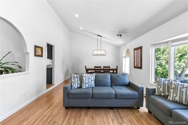 3253 S King Way, Denver, CO 80236 - living area with vaulted ceiling, arched walkways, a chandelier, light wood-style flooring, and baseboards