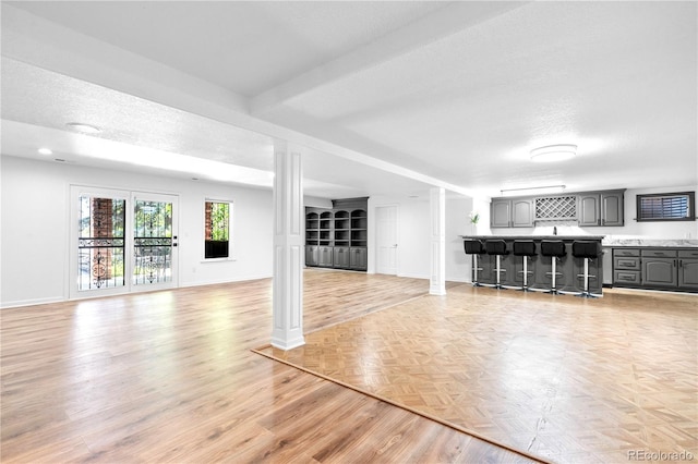 3253 S King Way, Denver, CO 80236 - unfurnished living room with baseboards, light wood finished floors, and a textured ceiling