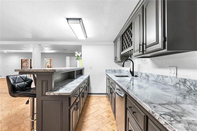3253 S King Way, Denver, CO 80236 - kitchen with a breakfast bar, a sink, dishwasher, light stone counters, and a peninsula