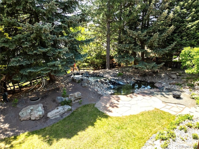3253 S King Way, Denver, CO 80236 - view of grassy yard with an outdoor fire pit and a garden pond