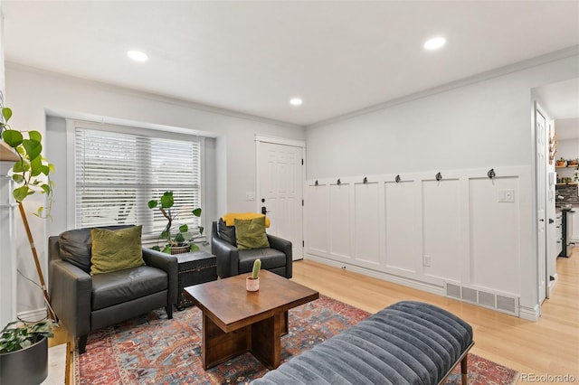 living room featuring light hardwood / wood-style floors and ornamental molding