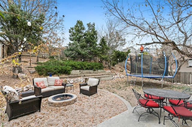 view of patio / terrace featuring a trampoline and an outdoor living space with a fire pit