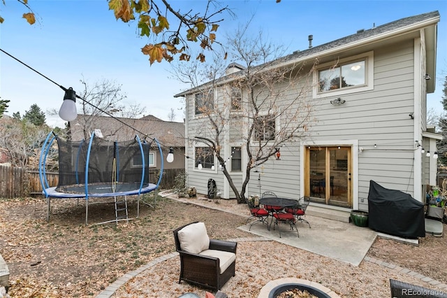 rear view of property with a patio and a trampoline