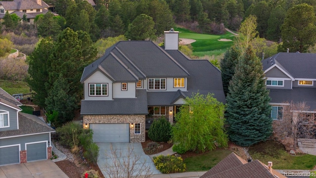 7071 Turweston Ln, Castle Pines, CO 80108 - view of front of house featuring stone siding, concrete driveway, a chimney, an attached garage, and a shingled roof