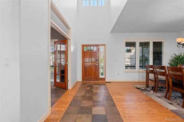 7071 Turweston Ln, Castle Pines, CO 80108 - foyer featuring stone tile floors, baseboards, and a high ceiling
