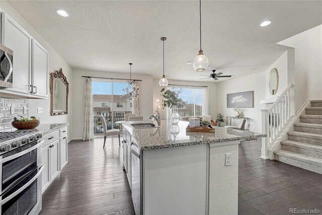 14902 E Poundstone Dr, Aurora, CO 80015 - kitchen featuring appliances with stainless steel finishes, a sink, ceiling fan, white cabinetry, and light stone countertops