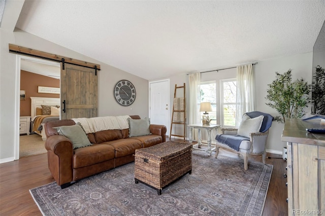 16580 Sagecreek Rd, Peyton, CO 80831 - living area featuring a barn door, lofted ceiling, wood finished floors, a textured ceiling, and baseboards