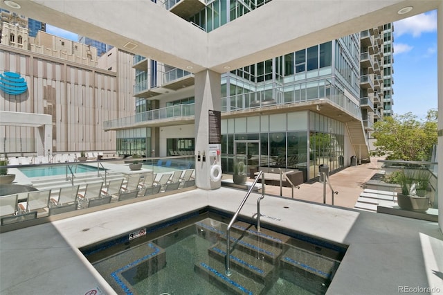 view of swimming pool with a community hot tub