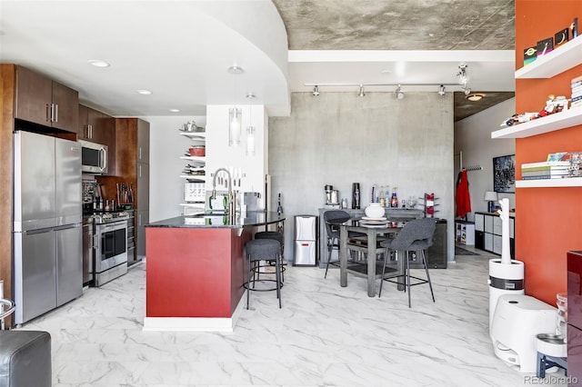 891 14th St Unit 2816, Denver, CO 80202 - kitchen featuring stainless steel appliances, a sink, dark countertops, a kitchen breakfast bar, and light marble finish floors