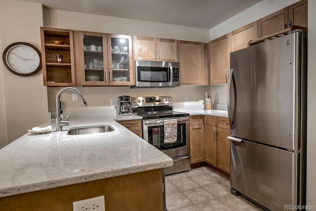 105 Wheeler Cir Unit 334, Frisco, CO 80443 - kitchen featuring stainless steel appliances, light stone countertops, glass insert cabinets, and brown cabinets