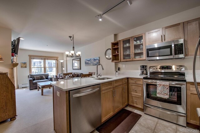 105 Wheeler Cir Unit 334, Frisco, CO 80443 - kitchen with stainless steel appliances, a baseboard radiator, open floor plan, a peninsula, and glass insert cabinets