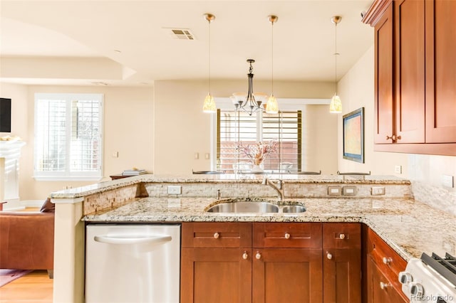 kitchen with light stone countertops, range, dishwasher, sink, and kitchen peninsula