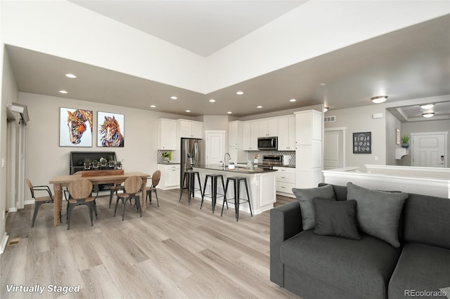 living room with light hardwood / wood-style flooring and sink