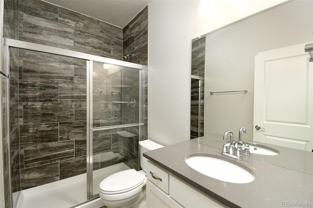 bathroom with vanity, toilet, and a shower with shower door