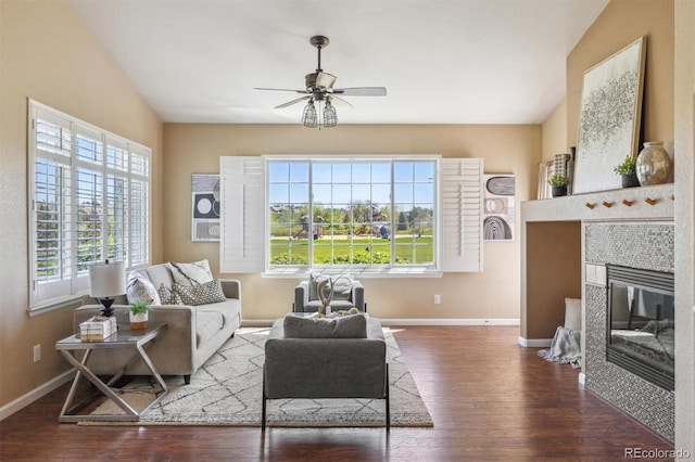 living room with wood finished floors, ceiling fan, baseboards, and a tiled fireplace