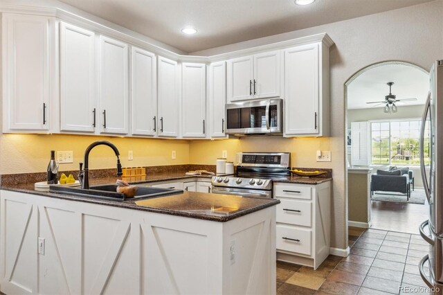 kitchen featuring stainless steel appliances, white cabinetry, a peninsula, recessed lighting, and a sink