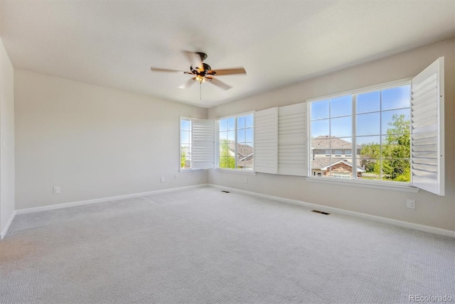 empty room with ceiling fan, baseboards, and carpet
