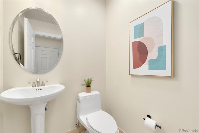 1827 N Grant St Unit 604, Denver, CO 80203 - bathroom featuring toilet, baseboards, and a sink