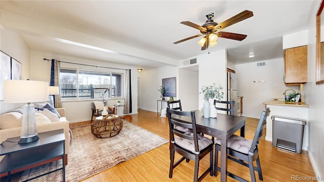 dining area featuring light wood-type flooring, visible vents, ceiling fan, and baseboards