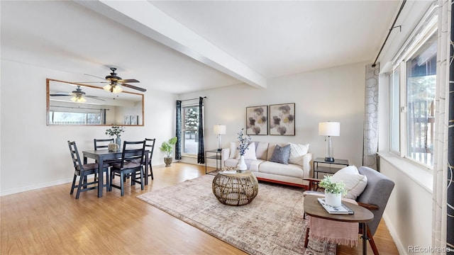 living area with light wood finished floors, beam ceiling, and a wealth of natural light