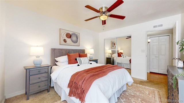 bedroom featuring a closet, visible vents, a ceiling fan, light carpet, and baseboards