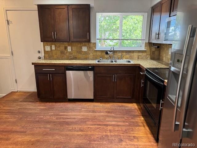 16753 E Ithaca Pl, Aurora, CO 80013 - kitchen with appliances with stainless steel finishes, light wood-style flooring, decorative backsplash, and dark brown cabinetry