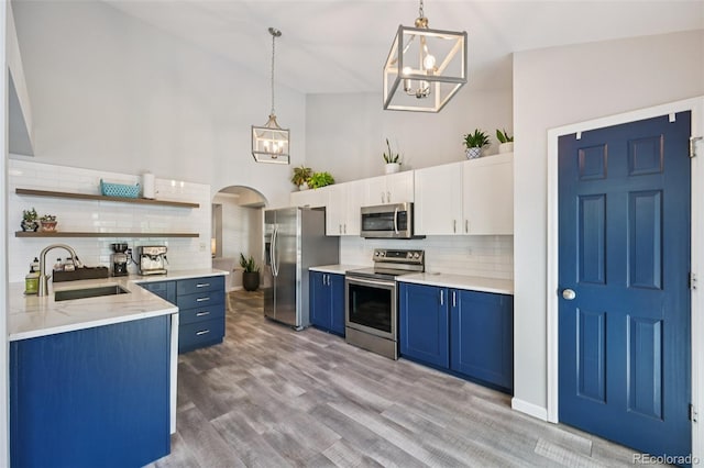 6468 S Forest St, Centennial, CO 80121 - kitchen with appliances with stainless steel finishes, blue cabinets, a chandelier, open shelves, and decorative backsplash