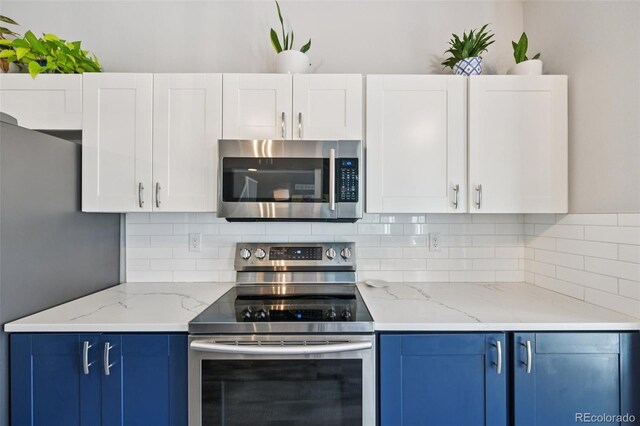 6468 S Forest St, Centennial, CO 80121 - kitchen with appliances with stainless steel finishes, blue cabinetry, decorative backsplash, and white cabinets
