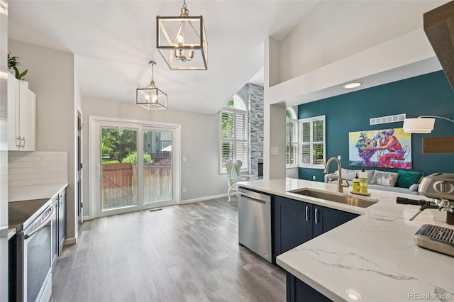 6468 S Forest St, Centennial, CO 80121 - kitchen with dishwasher, white range with electric cooktop, a chandelier, open floor plan, and light stone counters