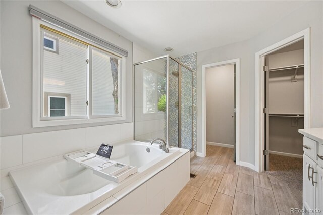 6468 S Forest St, Centennial, CO 80121 - bathroom with a shower stall, a bath, a walk in closet, wood finished floors, and vanity