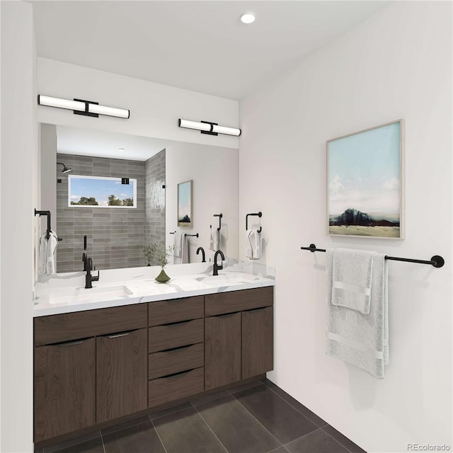 full bath featuring tile patterned floors, double vanity, a tile shower, and a sink