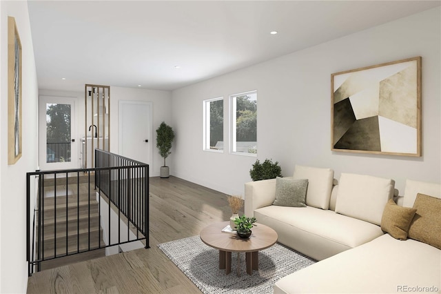 living room featuring recessed lighting, a healthy amount of sunlight, light wood-type flooring, and baseboards