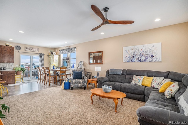 carpeted living room with ceiling fan