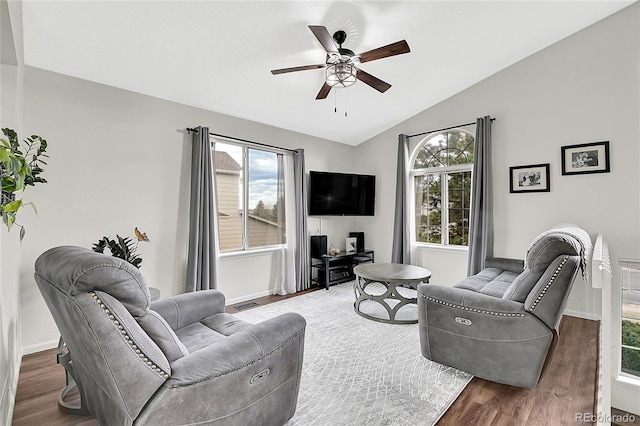 living area featuring dark wood-style floors, visible vents, vaulted ceiling, and a wealth of natural light