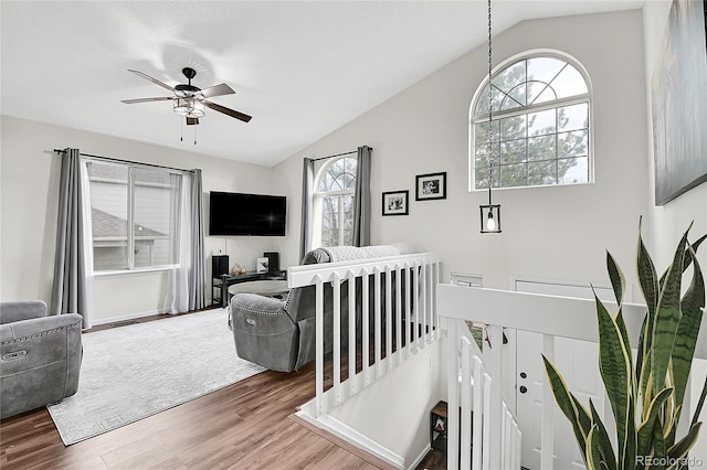 living room featuring ceiling fan, a wealth of natural light, vaulted ceiling, and wood finished floors