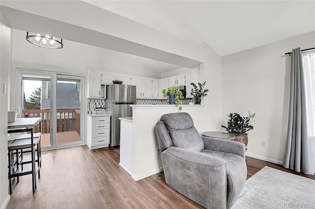 interior space with wood finished floors, a healthy amount of sunlight, white cabinets, light countertops, and appliances with stainless steel finishes