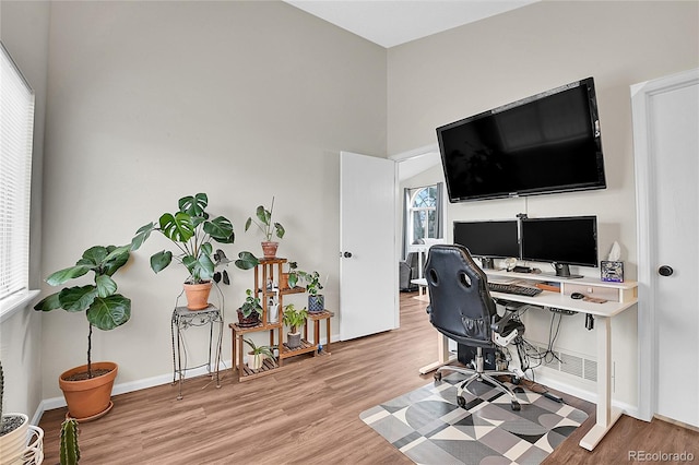 office area with light wood-style floors and baseboards