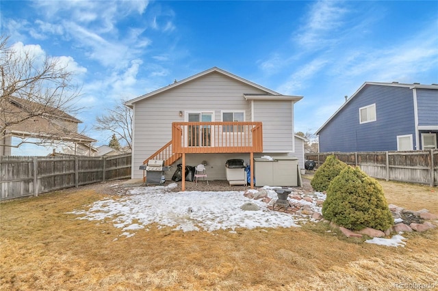 rear view of house with a deck, stairway, and a fenced backyard