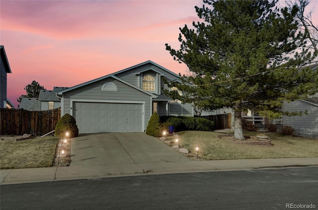 view of front of property featuring driveway, an attached garage, fence, and a front yard