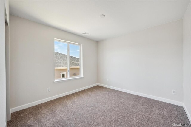 unfurnished room with baseboards and carpet flooring