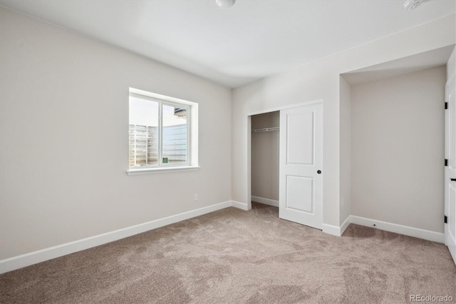 unfurnished bedroom with carpet flooring, baseboards, and a closet