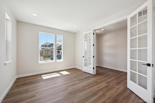 unfurnished room featuring baseboards, french doors, and wood finished floors