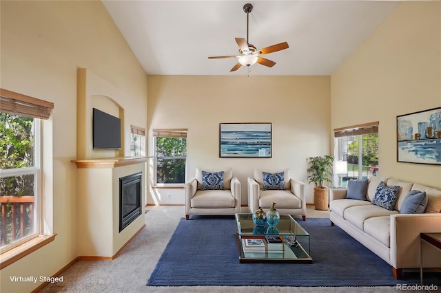 1481 Box Prairie Cir, Loveland, CO 80538 - carpeted living area featuring ceiling fan, a glass covered fireplace, baseboards, and high vaulted ceiling