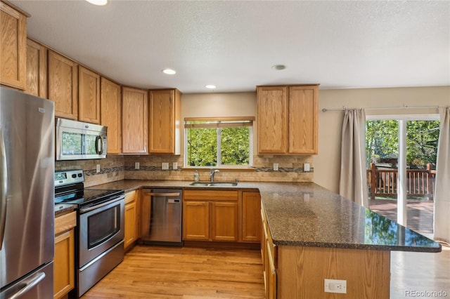 1481 Box Prairie Cir, Loveland, CO 80538 - kitchen with appliances with stainless steel finishes, a sink, a peninsula, backsplash, and recessed lighting