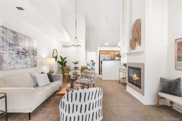 5444 Zephyr St Unit 203, Arvada, CO 80002 - carpeted living room with a towering ceiling, a fireplace, a chandelier, and baseboards
