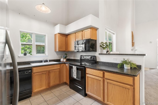 5444 Zephyr St Unit 203, Arvada, CO 80002 - kitchen featuring black appliances, a sink, a high ceiling, dark countertops, and light tile patterned floors
