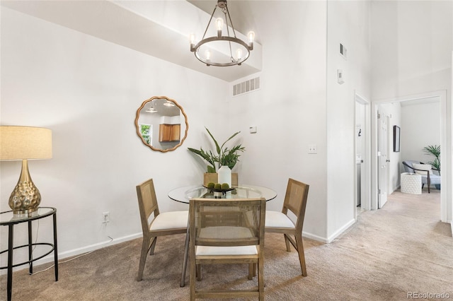 5444 Zephyr St Unit 203, Arvada, CO 80002 - dining area featuring carpet flooring, a chandelier, a towering ceiling, and baseboards